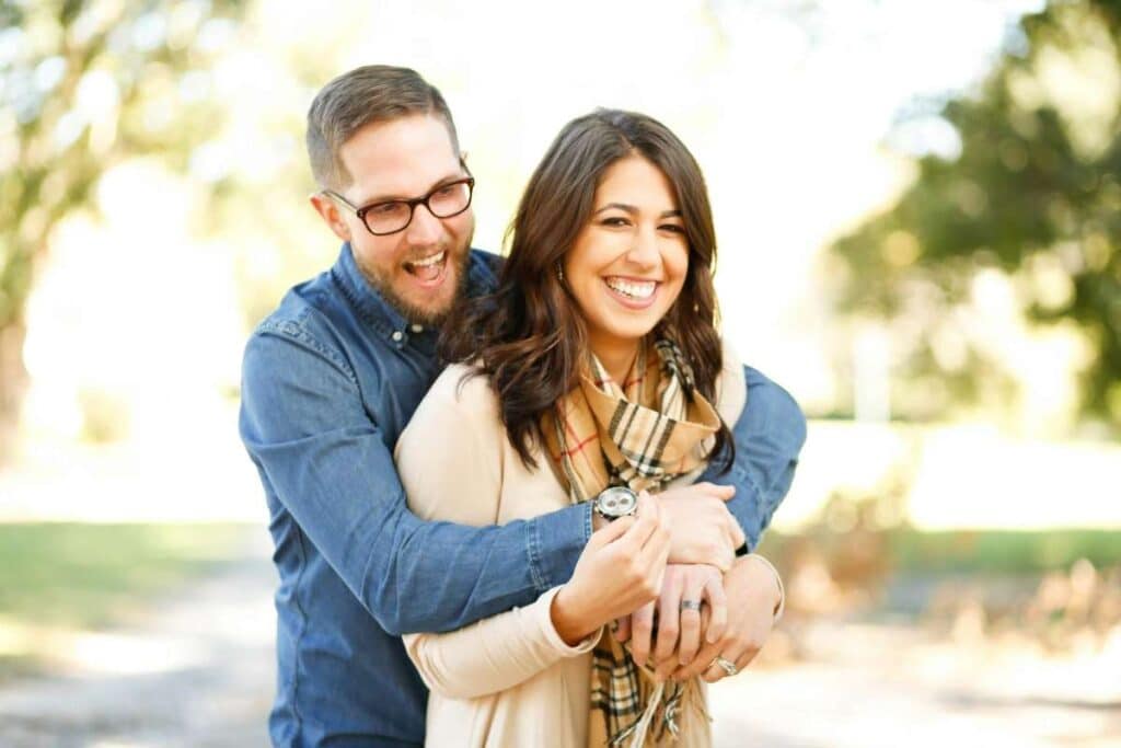 Smiling couple embracing outdoors, symbolizing restored love and connection through relationship counseling