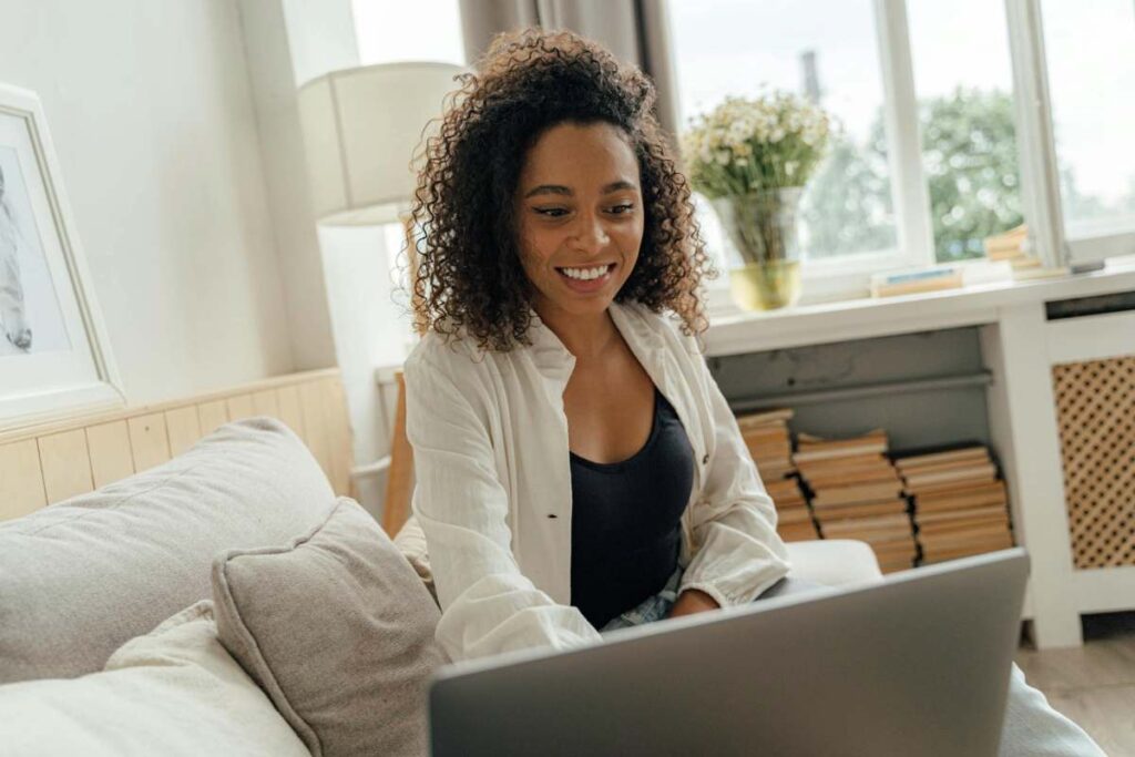 Smiling woman attending an online therapy session from home on her laptop